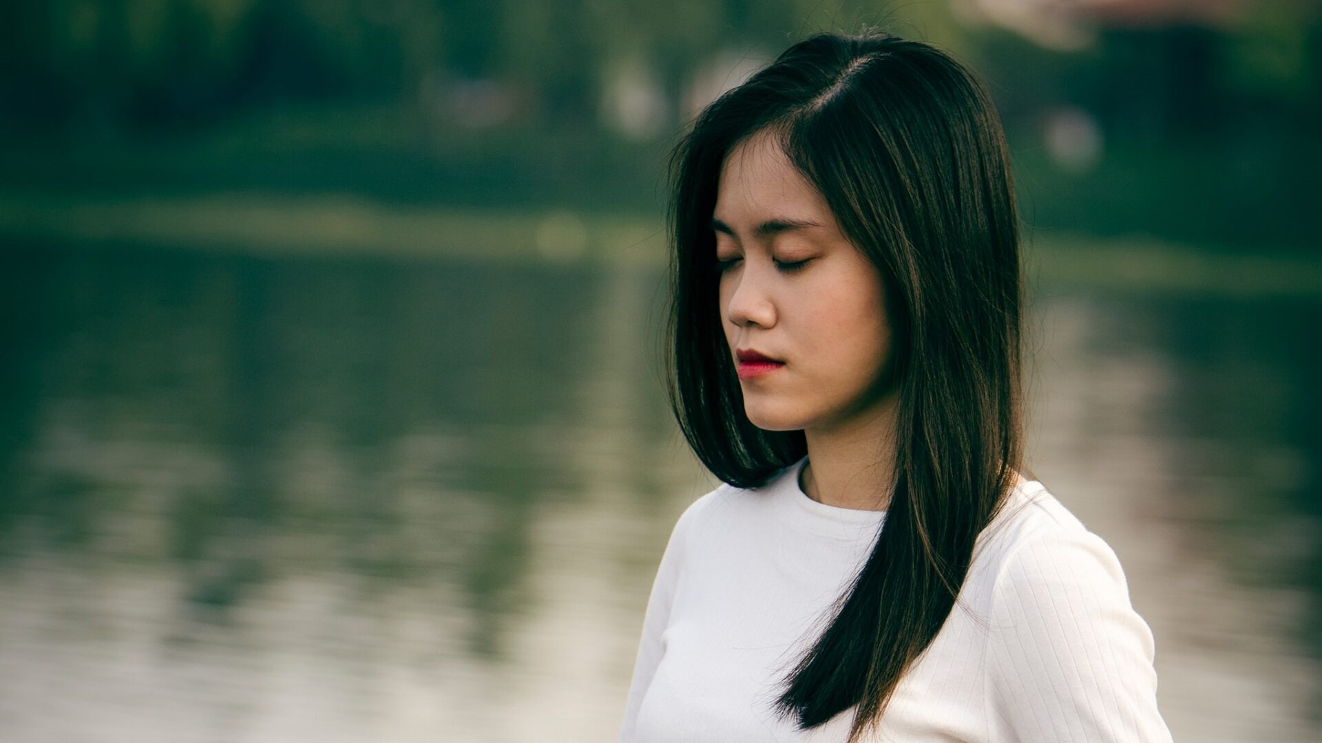 photo of a girl meditating by a lake